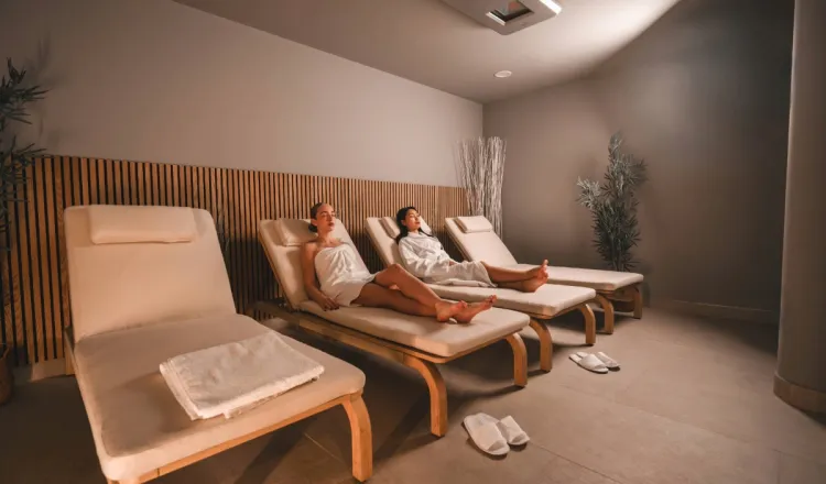 Zwei Damen liegen auf bequemen Liegen im Ruhebereich des Arkona Strandhotels Binz auf Rügen