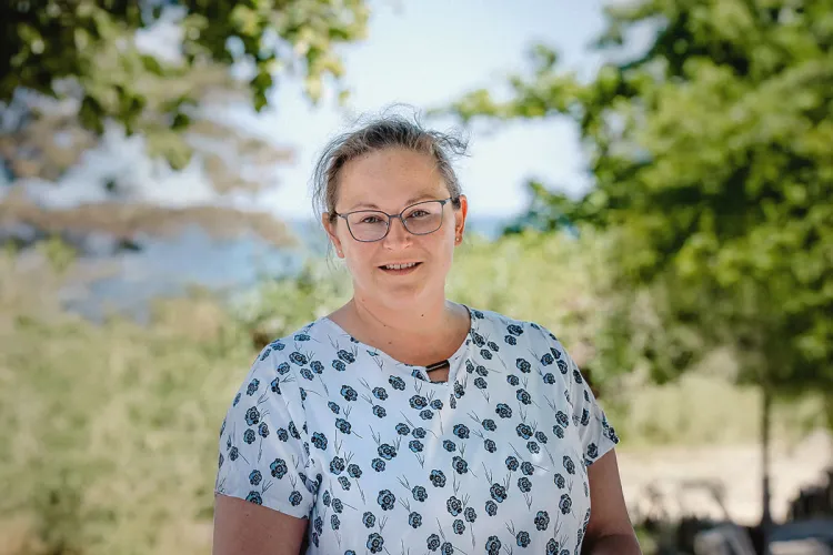 Mandy Lachmann, Leiterin Reservierung im Arkona Strandhotel, lächelnd am Strand von Binz