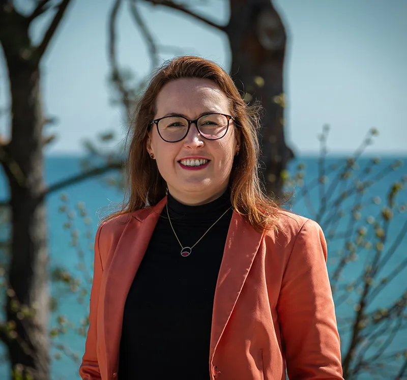 Potraitbild der Direktionsassistentin Dorothee Schicht vor der Ostsee, die bei Presse- und Kooperationsfragen der Arkona Hotels hilft.