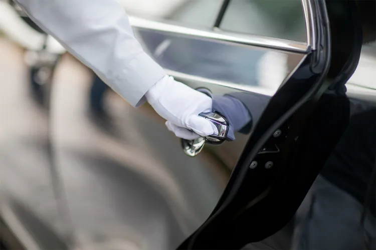 Der Chauffeur öffnet die Tür der eleganten Limousine des Arkona Strandhotels.