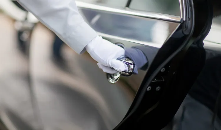 Der Chauffeur öffnet die Tür der eleganten Limousine des Arkona Strandhotels.