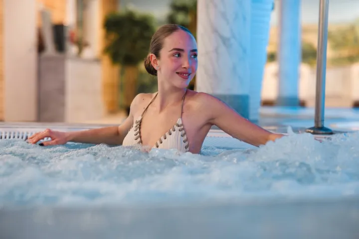 Frau entspannt im sprudelnden Pool eines Spa Hotels auf Rügen mit warmem Wasser und ruhiger Atmosphäre