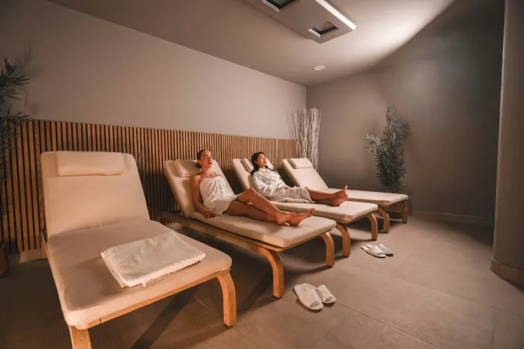 Zwei Damen liegen auf bequemen Liegen im Ruhebereich des Arkona Strandhotels Binz auf Rügen