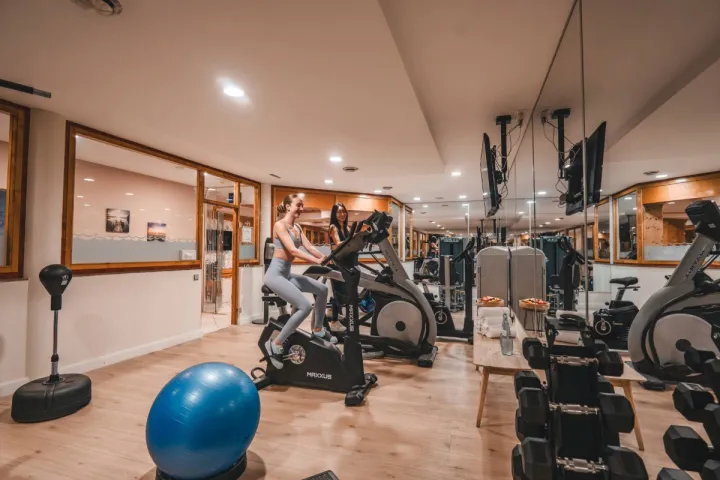 Fitnessraum im Spa Hotel auf Rügen mit Cardio Geräten, Hanteln und Spiegeln für aktives Training.