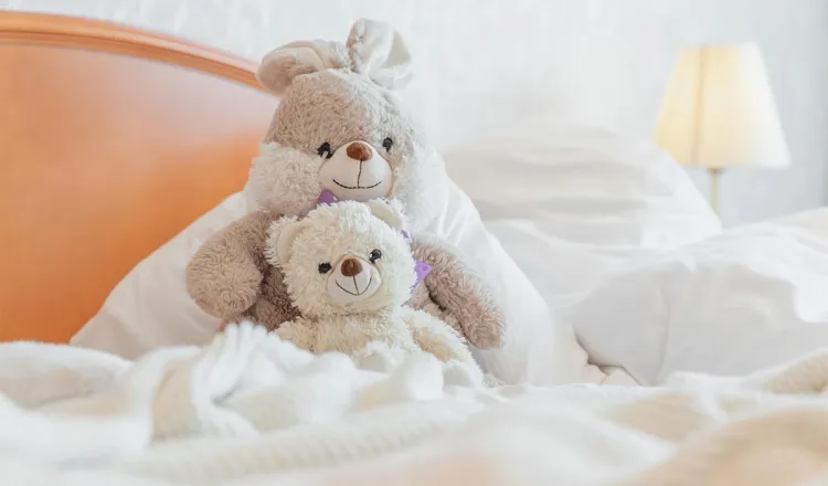 Die Kuscheltiere eines jungen Hotelgastes bei enem Familienurlaub auf Rügen genießen den Komfort des Zustellbettes im Familienzimmer.