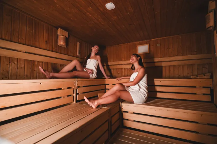 Zwei Damen entspannen in der Sauna im Arkona Strandhotel Binz auf Rügen mit Holzbänken und ruhiger Atmosphäre
