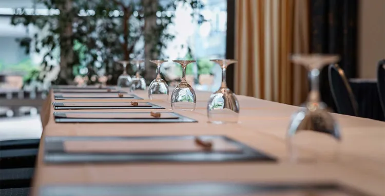 Gläser und Schreibunterlagen sind aufgereiht auf einem Tisch im Tagungsraum im Arkona Strandhotel in Binz auf Rügen.