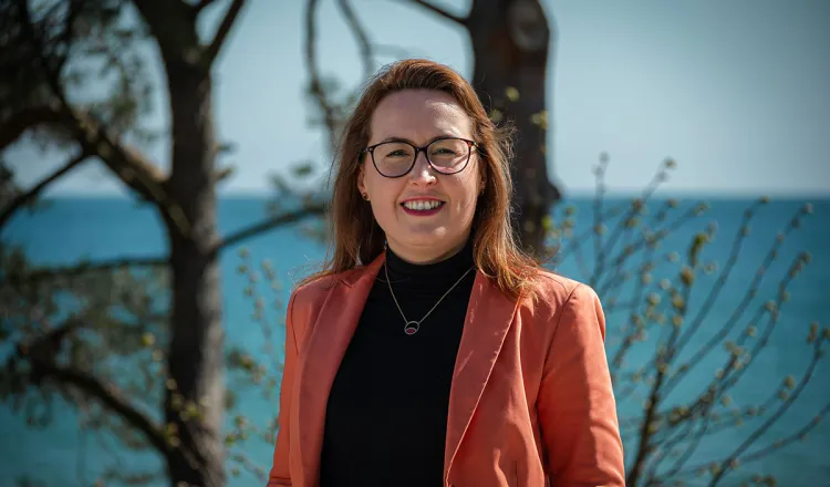 Dorothee Schicht am Strandübergang in Binz bei Sonne – Executive Assistant im Arkona Strandhotel und tragende Stütze im Hintergrund