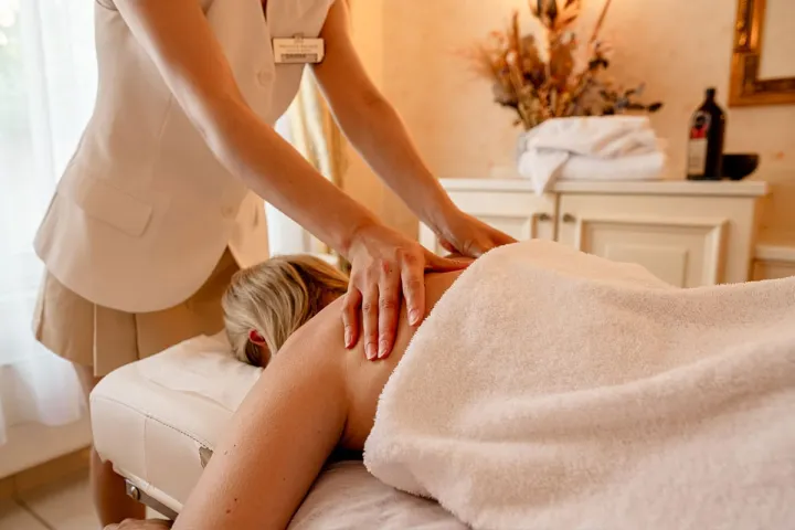 Der Rücken einer Frau wird während einer Massage im Spa Hotel auf Rügen massiert.