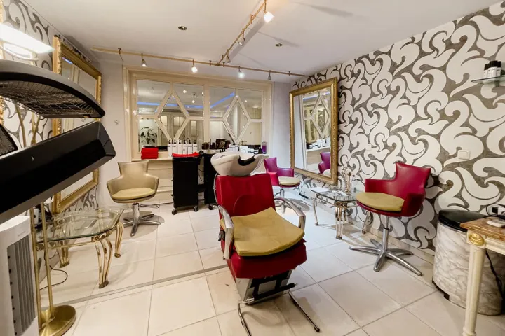Exklusiver Friseursalon mit roten Sesseln und goldenen Akzenten im Spa Hotel auf Rügen.