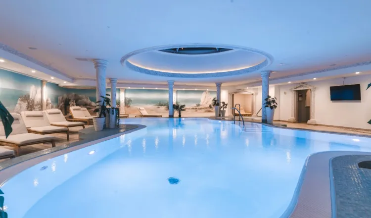 Innenpool im Arkona Strandhotel Binz auf Rügen mit Liegen, Säulen und ruhiger Atmosphäre für entspannte Stunden