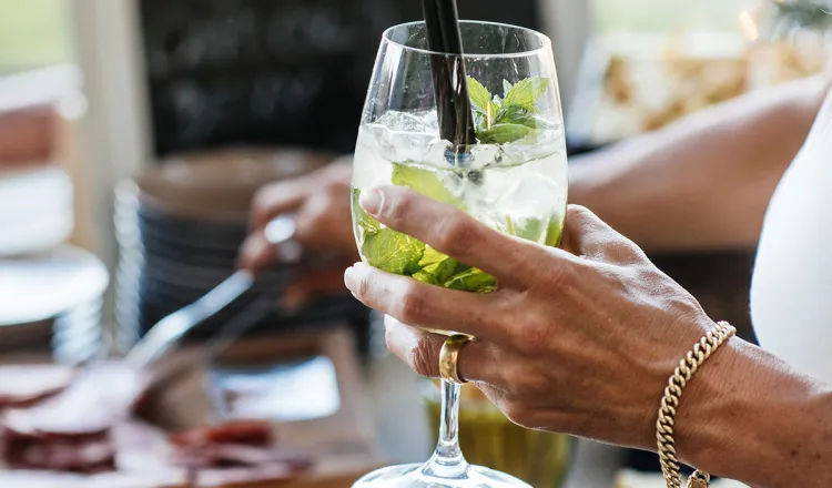 Detailaufnahme einer Frau, die einen Cocktail in der Hand hält bei einem Bankett im Arkona Strandhotel in Binz auf Rügen.