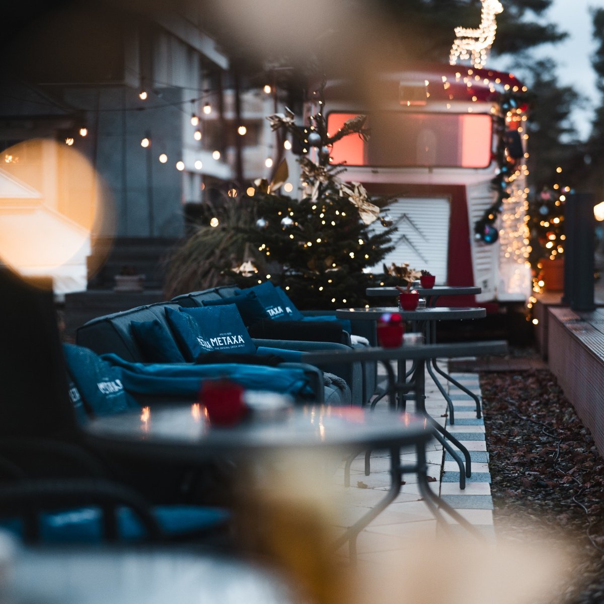 Gemütliche Hotelterrasse mit weihnachtlicher Dekoration, Lichterketten, Sitzgelegenheiten und festlicher Atmosphäre in der Adventszeit.