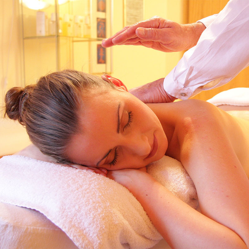 Frau liegt entspannt auf einer Liege und erhält eine klassische Rückenmassage im Arkona Strandhotel Rügen