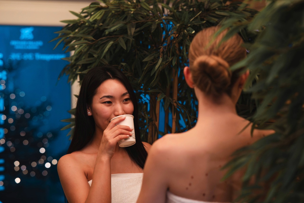 Zwei Damen trinken Tee im Wellnessbereich des Arkona Strandhotels Binz auf Rügen zwischen Pool und Saunabereich